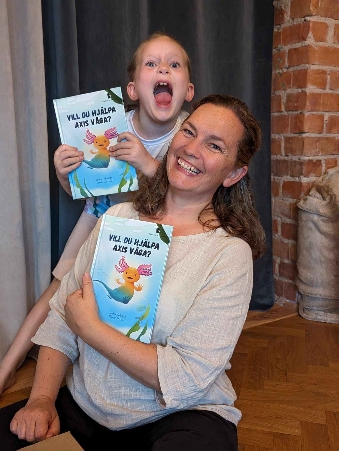 Författaren Jessica Hellström tillsammans med dottern Ellie, när boken om Axis först kom hem från tryckeriet. Vill du hjälpa Axis våga? - en interaktiv barnbok som syftar till att till att hjälpa barn att stärka sig själva.
